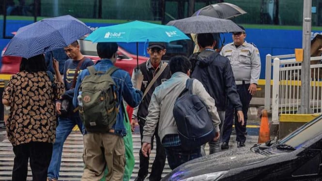 Warga berjalan menggunakan payung saat turun hujan di Jakarta. (Foto ilustrasi)
