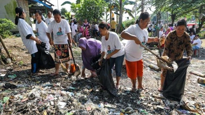 Nelayan bergotong royong membersihkan sampah di pesisir muara Sungai Bondet