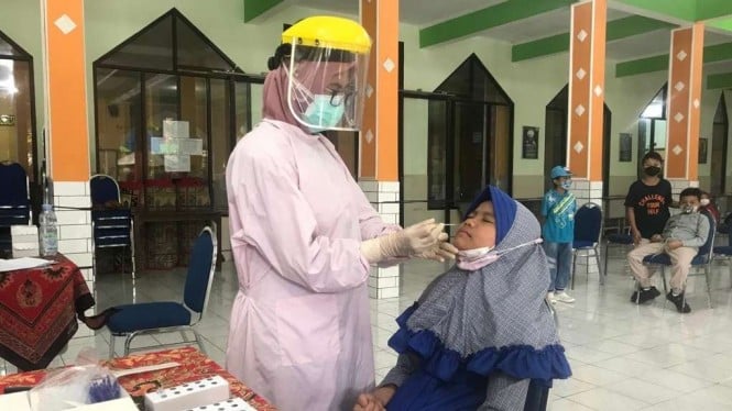 Seorang siswi Madrasah Ibtidaiyah Negeri (MIN) 1 Kota Malang, Jawa timur, dites swab pada Kamis, 20 Januari 2022, menyusul penularan COVID-19 di sekolah itu dengan seorang pelajar terinfeksi dari keluarganya.