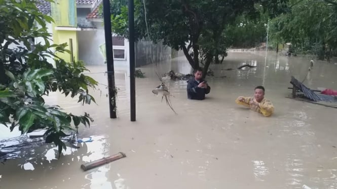 Warga berusaha menerjang genangan banjir di Perum Dinar Indah Semarang